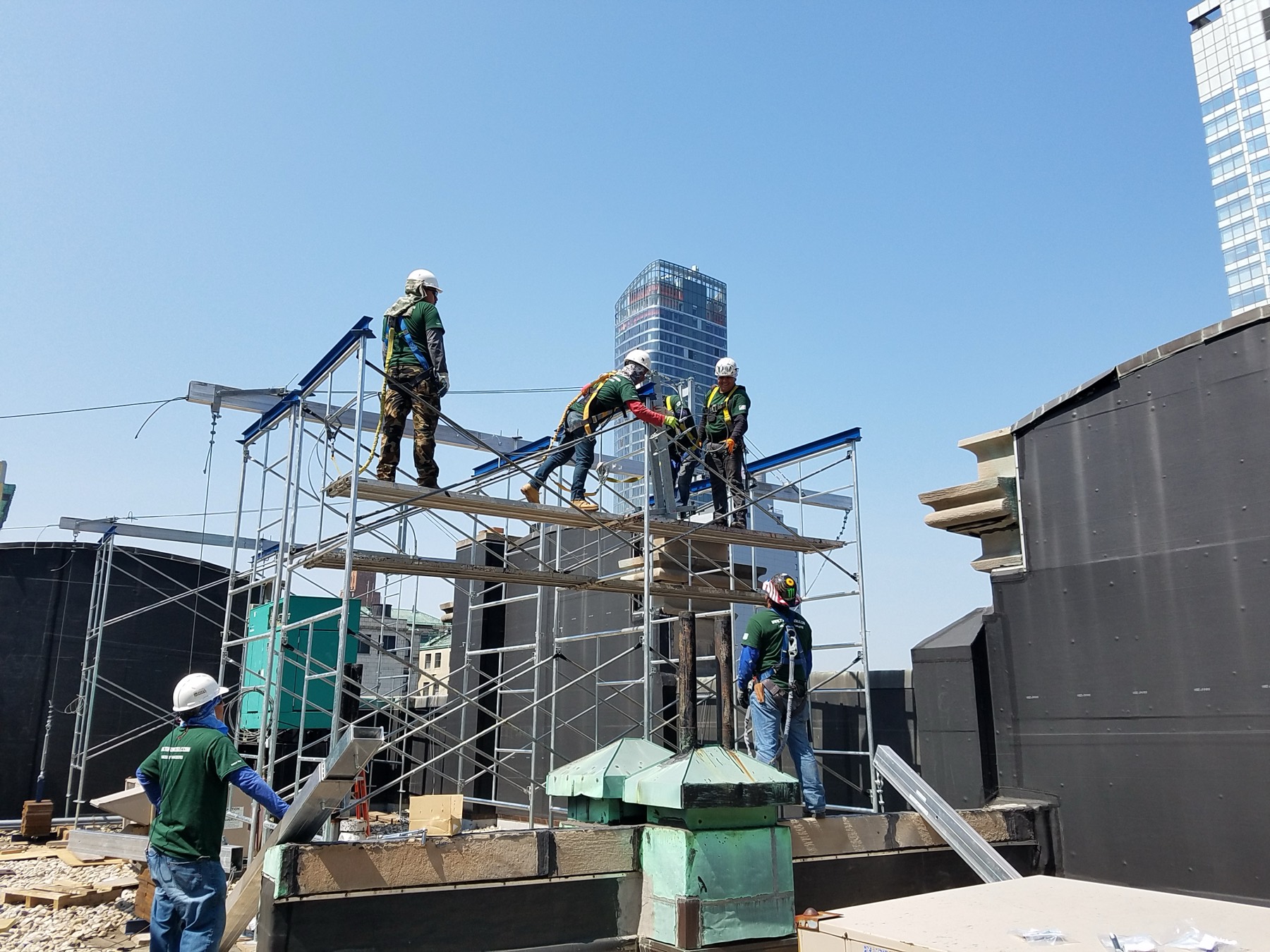 A Titan Construction crew erecting rooftop scaffolding on a Manhattan high-rise